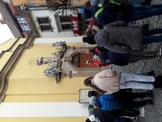 Dzieci otaczają półkręgiem panią przewodnik - która stoi przed Jelenio Górską katedrą i opowiada jej historię.jpg