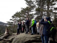 Grupa dzieci ogląda górski widok stojąc na skale.jpg