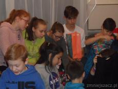 Na zdjęciu widać dzieci rozpakowujące prezenty.JPG