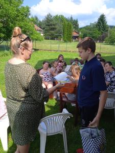 wychowanek-otrzymuje-od-pani-pedagog-nagrode-za-aktywny-udzial-w-zyciu-placowki-w-czasie-zakonczenia-roku-szkolnego.jpg