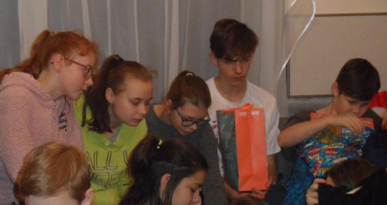 Na zdjęciu widać dzieci rozpakowujące prezenty.JPG