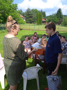 wychowanek-otrzymuje-od-pani-pedagog-nagrode-za-aktywny-udzial-w-zyciu-placowki-w-czasie-zakonczenia-roku-szkolnego.jpg